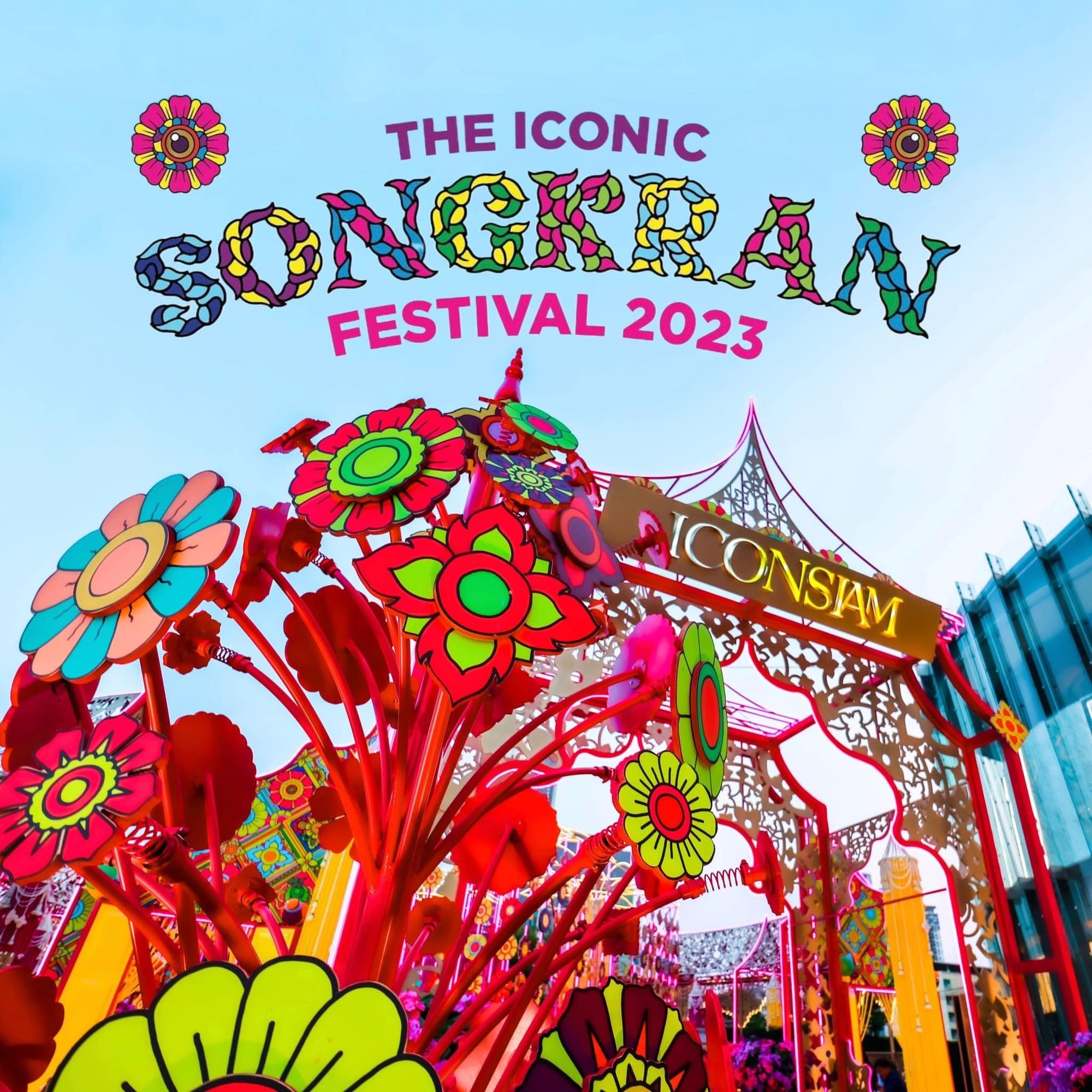 ดอกไม้หลากสี บนก้านสีแดง อยู่หน้าซุ้มประดับป้าย ICONSIAM มีข้อความ THE ICONIC SONGKRAN FESTIVAL 2023 ด้านบน และอาคารกระจกทางขวา
